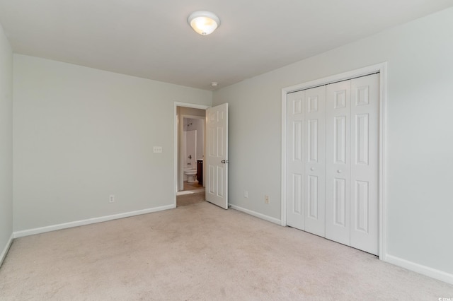 unfurnished bedroom featuring light carpet and a closet