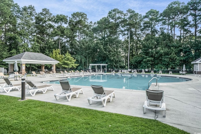 view of swimming pool featuring a lawn and a patio