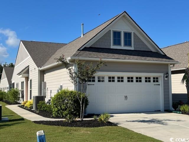 view of front of home with concrete driveway, roof with shingles, and central AC