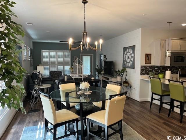 dining space featuring a notable chandelier, visible vents, and dark wood finished floors