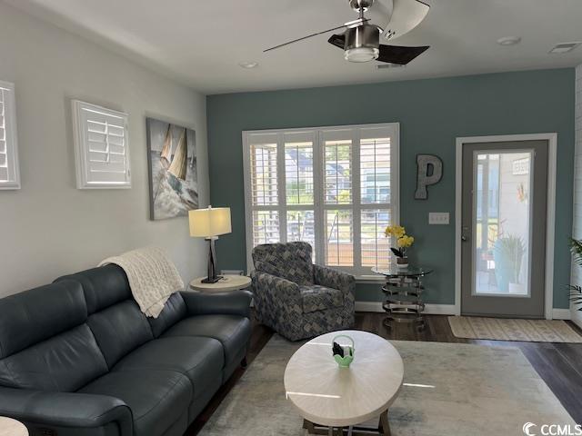 living room with ceiling fan, baseboards, visible vents, and wood finished floors