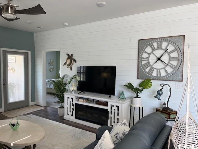 living area with wood finished floors and ceiling fan