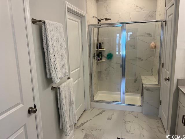 bathroom featuring a stall shower, vanity, and marble finish floor