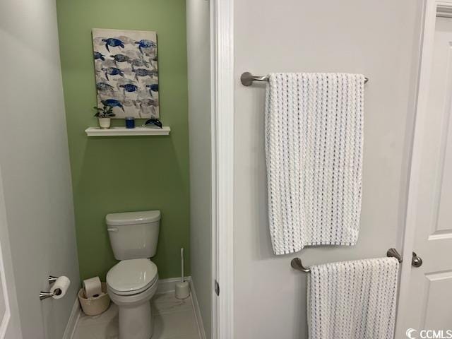 bathroom with toilet and baseboards