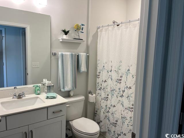 full bathroom with toilet, vanity, and a shower with curtain