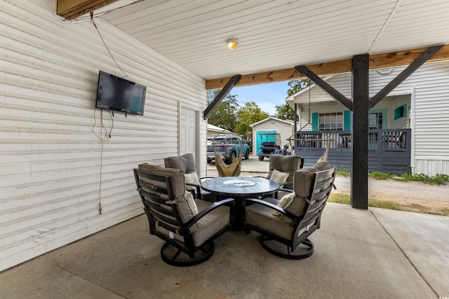 view of patio with outdoor dining area, an outbuilding, and a storage shed