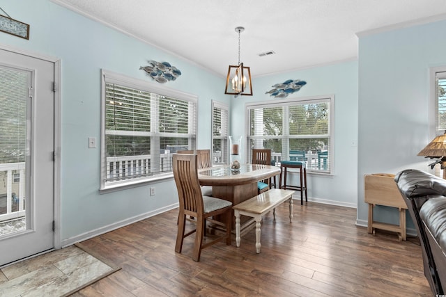 dining space with a notable chandelier, crown molding, visible vents, and wood-type flooring