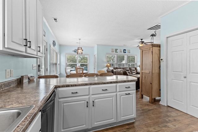 kitchen featuring visible vents, ceiling fan with notable chandelier, a peninsula, and black dishwasher