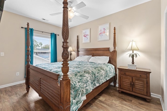 bedroom with visible vents, a ceiling fan, baseboards, and wood finished floors