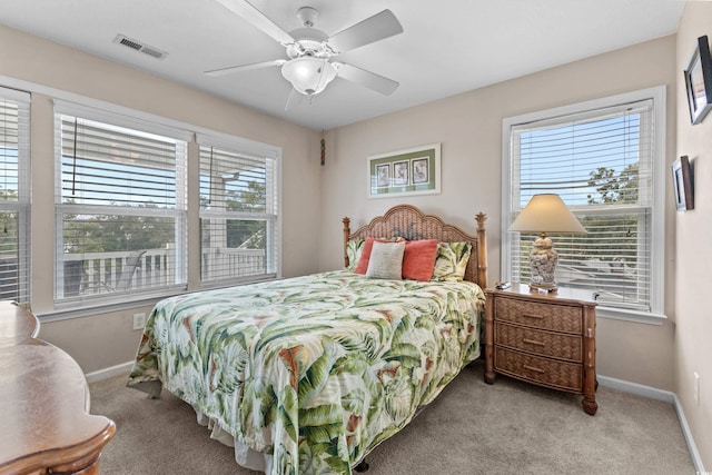 carpeted bedroom featuring multiple windows, baseboards, and visible vents