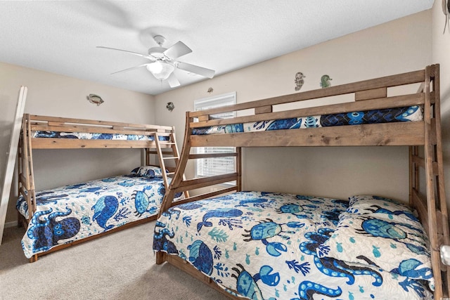 bedroom with carpet flooring, a ceiling fan, and a textured ceiling