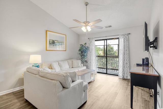 living room with lofted ceiling, ceiling fan, and light wood-type flooring