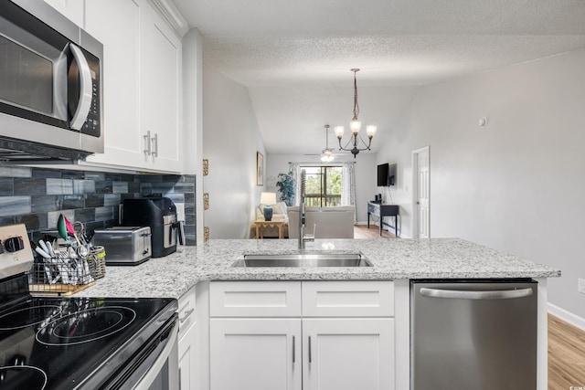 kitchen with tasteful backsplash, light hardwood / wood-style floors, stainless steel appliances, sink, and white cabinets