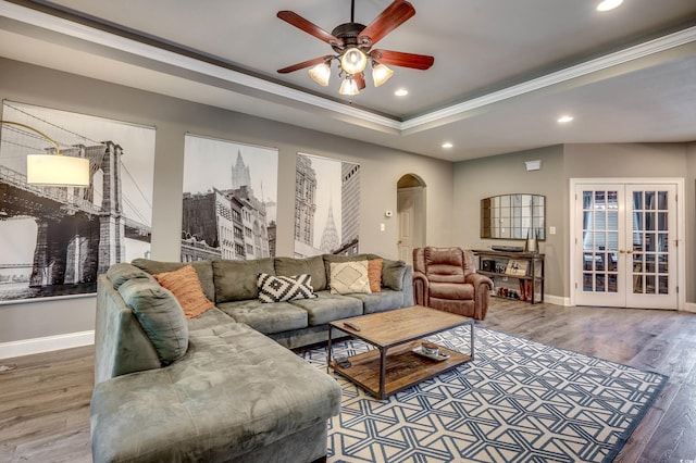 living room featuring ceiling fan, a raised ceiling, french doors, and hardwood / wood-style floors