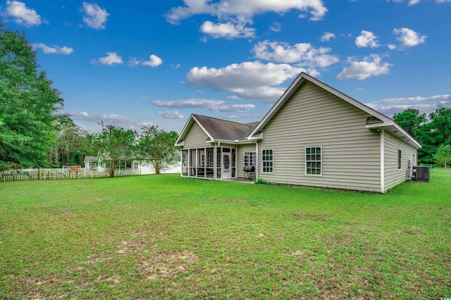 rear view of property with a yard, a sunroom, and central air condition unit