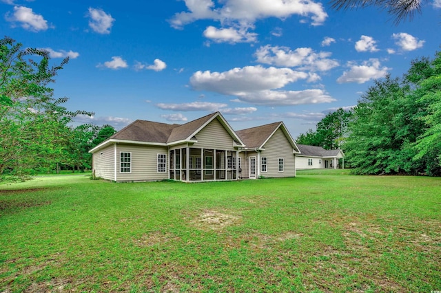 rear view of property featuring a lawn and a sunroom