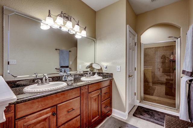 bathroom with tile patterned flooring, vanity, and a shower with door