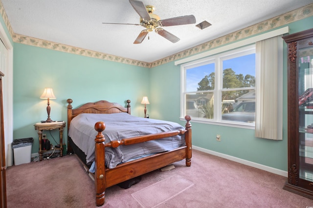 carpeted bedroom featuring a ceiling fan, a textured ceiling, and baseboards