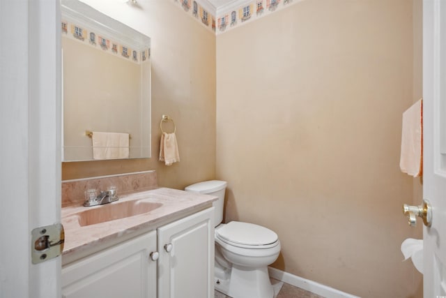 bathroom featuring toilet, vanity, and baseboards