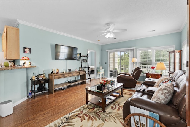 living room with ornamental molding, ceiling fan, and dark wood-type flooring