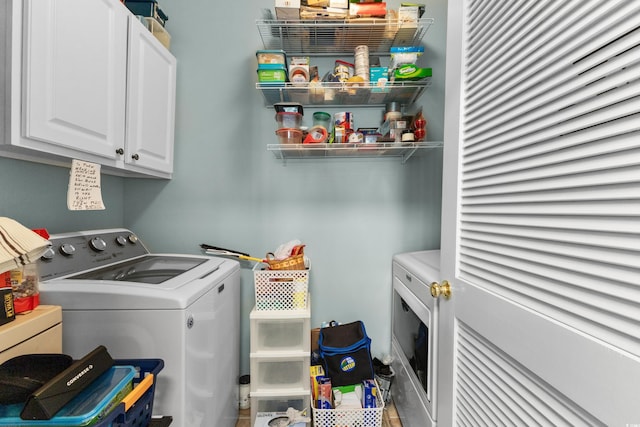 clothes washing area with cabinets and separate washer and dryer