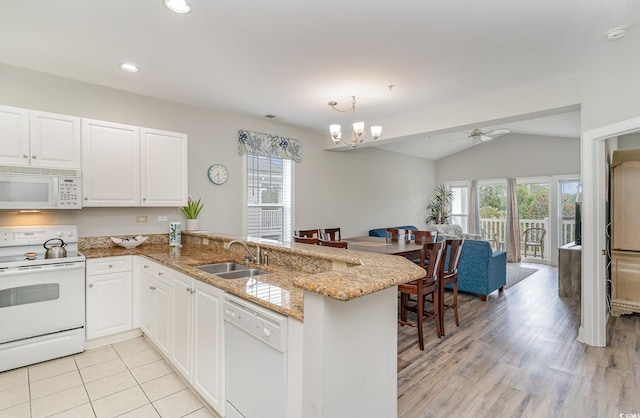 kitchen with white cabinets, sink, kitchen peninsula, and white appliances