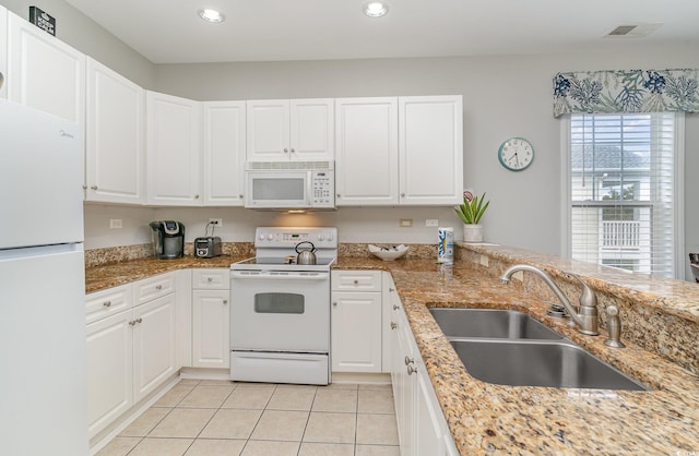 kitchen with white cabinets, sink, and white appliances