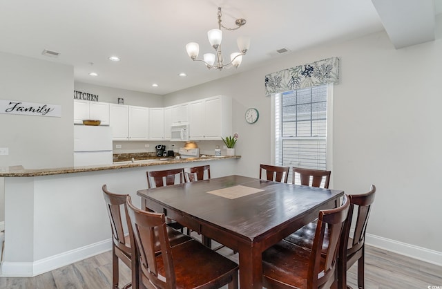 dining area featuring a chandelier and light hardwood / wood-style floors