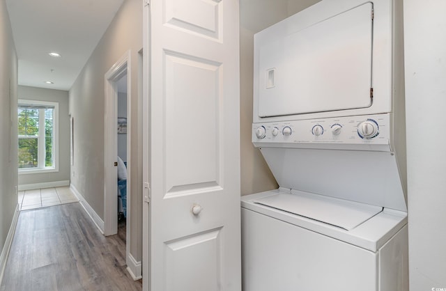 laundry area featuring light wood-type flooring and stacked washing maching and dryer