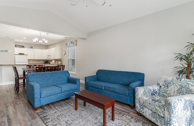 living room featuring ceiling fan with notable chandelier, vaulted ceiling, and hardwood / wood-style floors