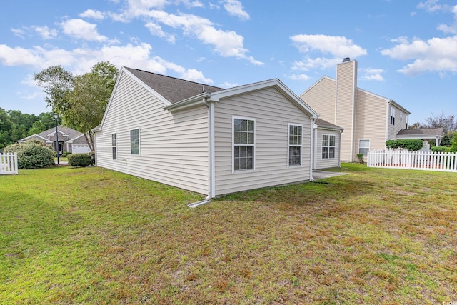 rear view of house featuring a lawn