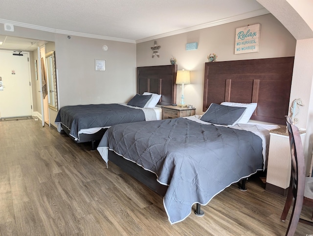 bedroom with hardwood / wood-style flooring and crown molding