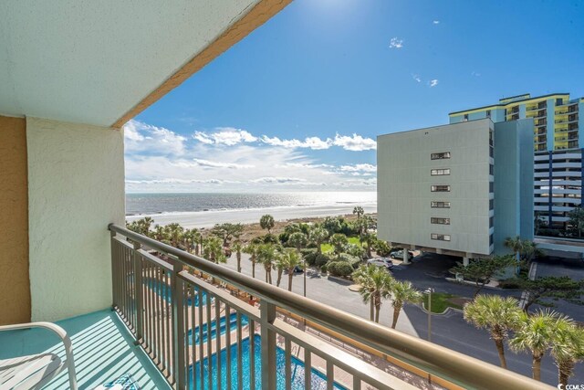 balcony featuring a view of the beach and a water view