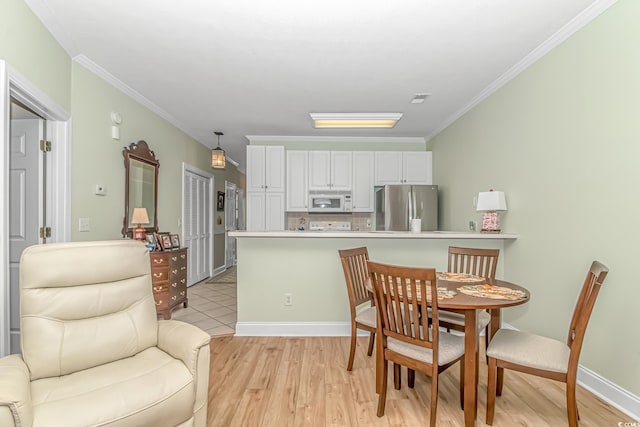 dining area featuring light hardwood / wood-style floors and crown molding