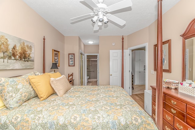 bedroom featuring ceiling fan, connected bathroom, a textured ceiling, hardwood / wood-style flooring, and a closet