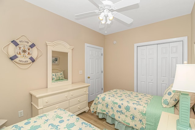 bedroom featuring light hardwood / wood-style floors, ceiling fan, and a closet