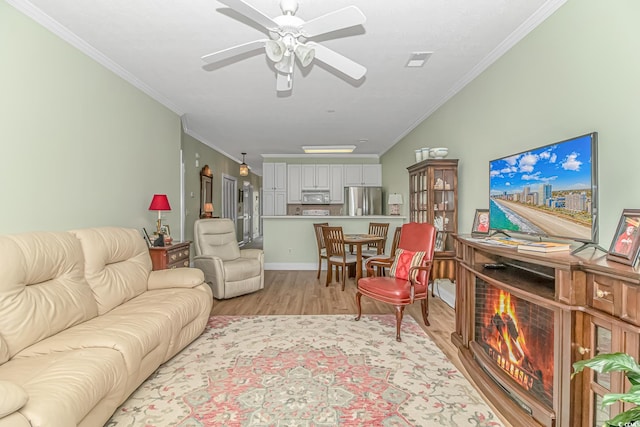 living room featuring ceiling fan, ornamental molding, and light hardwood / wood-style floors