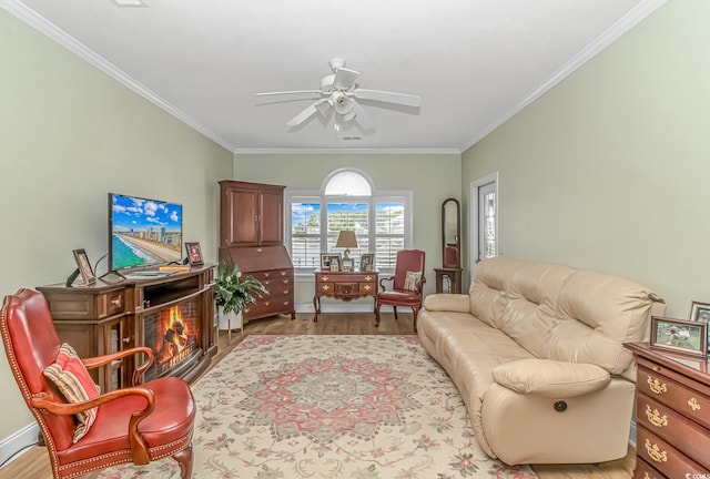 living room with crown molding, light hardwood / wood-style floors, a fireplace, and ceiling fan