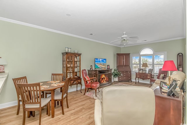 living room with ceiling fan, light wood-type flooring, and crown molding