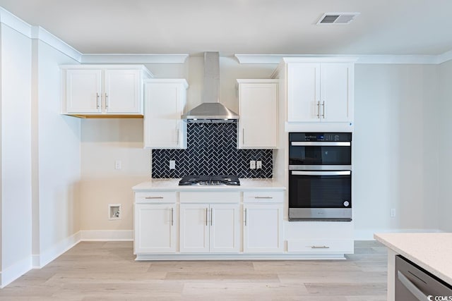 kitchen with white cabinets, wall chimney exhaust hood, and stainless steel appliances