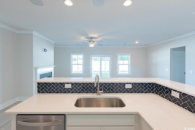 kitchen with decorative backsplash, ornamental molding, sink, dishwasher, and white cabinetry