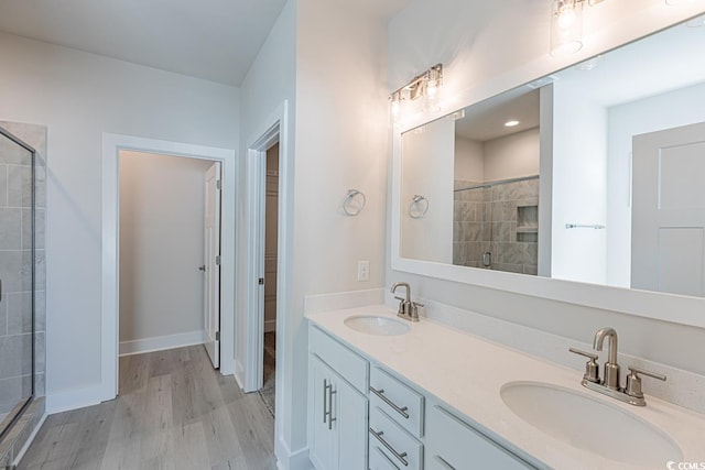 bathroom with hardwood / wood-style floors, vanity, and an enclosed shower