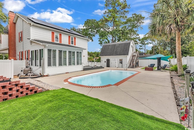 view of swimming pool with a lawn, an outdoor structure, and a patio area