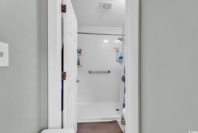 bathroom with a shower with curtain, a textured ceiling, and toilet