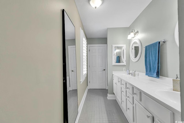 bathroom with tile patterned flooring, a textured ceiling, and vanity