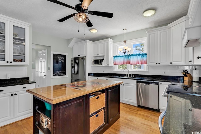 kitchen featuring ceiling fan with notable chandelier, stainless steel appliances, and white cabinets