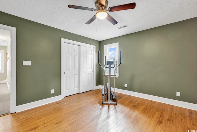 unfurnished bedroom featuring a textured ceiling, ceiling fan, and light hardwood / wood-style flooring