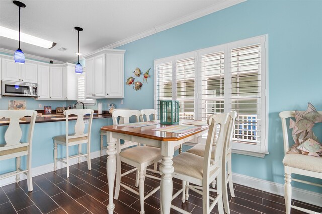 117B Ocean Blvd S, Surfside Beach, SC 29575 - dining area featuring wood tiled floor, plenty of natural light, crown molding, and baseboards