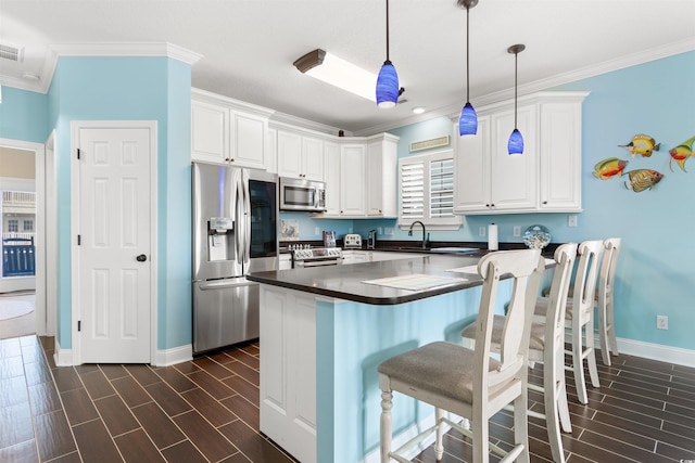 kitchen with pendant lighting, white cabinetry, stainless steel appliances, dark hardwood / wood-style floors, and crown molding