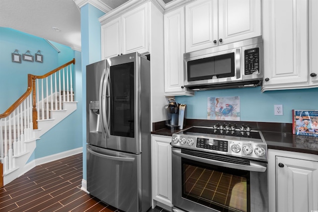 kitchen with stainless steel appliances, crown molding, dark hardwood / wood-style flooring, and white cabinetry